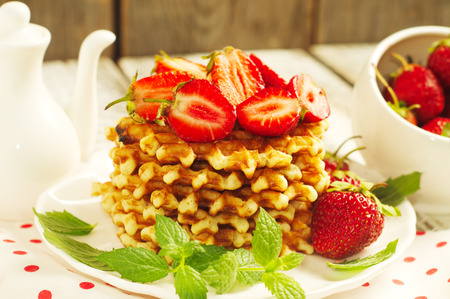French waffles with strawberries and leaves of mint. Selective focusの写真素材