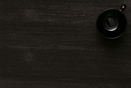 Black empty cup on black wooden kitchen table background with copy space.の写真素材
