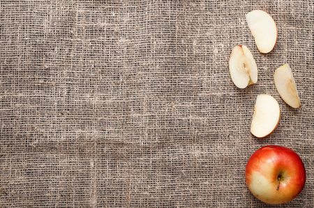 Sliced apple on burlap cloth background with copy space. Fruit compote ingredient.の写真素材