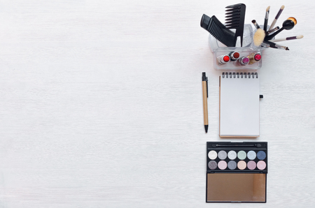 Make up or visage background. Blank page notepad and different cosmetic accessories in the holder with copy space.の写真素材