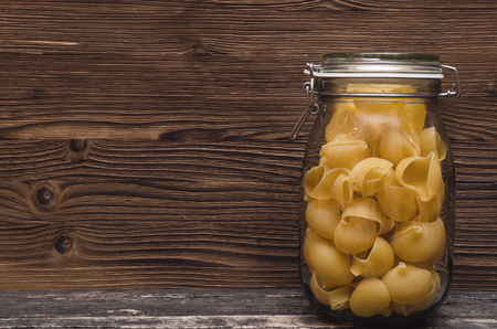 Pasta macaroni concept background with copy space. Pasta in a glass jar container. の写真素材
