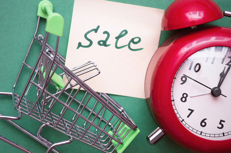 Shopping cart, red alarm clock and shopping list isolated on color background. Time to shop.の写真素材