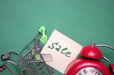 Shopping cart, red alarm clock and shopping list isolated on color background. Time to shop.の写真素材