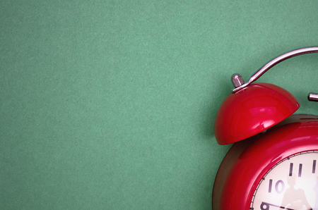 Red alarm clock face isolated on green background.の写真素材