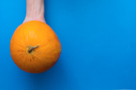 Hands is holding a fresh Melon isolated on the blue background.の写真素材
