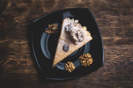 A piece of cake with walnuts on a plate.の写真素材