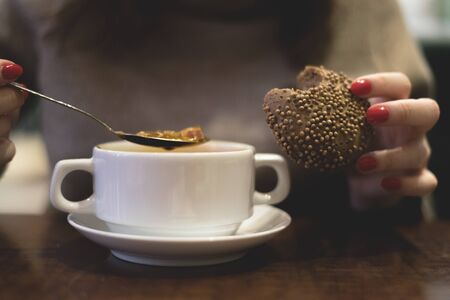 Woman is eating a tasty soup with a bread in a dinning room.の写真素材