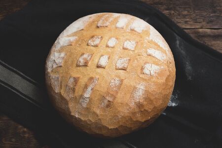 Baked bread on a wooden table background.