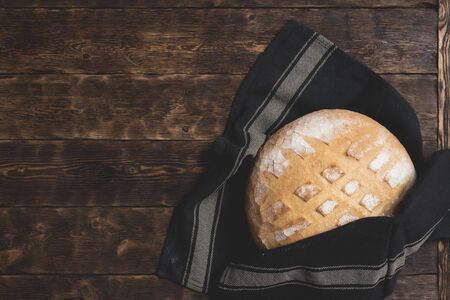 Baked bread on a wooden table background.