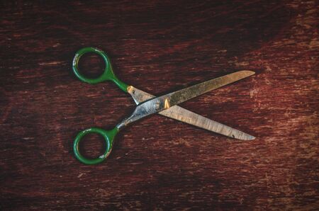 Old scissors on a wooden table abstract background.の写真素材