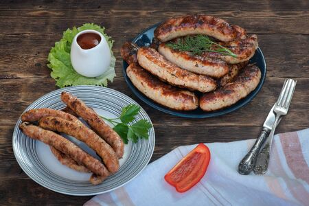 A grilled sausages on a plate on a kitchen table background.の写真素材