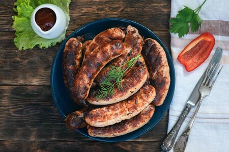A grilled sausages on a plate on a kitchen table background.の写真素材