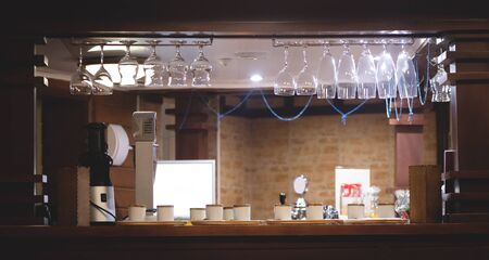 Bar counter abstract background with wine glasses hanging above.