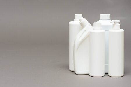 Detergent bottles on gray background.