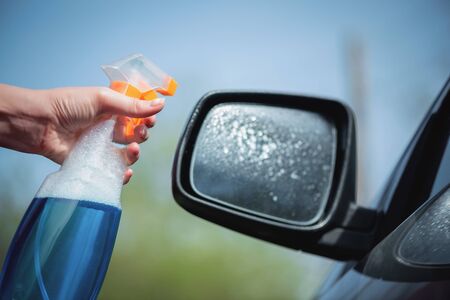 Cleaner is cleaning a car exterior mirror close up.の写真素材