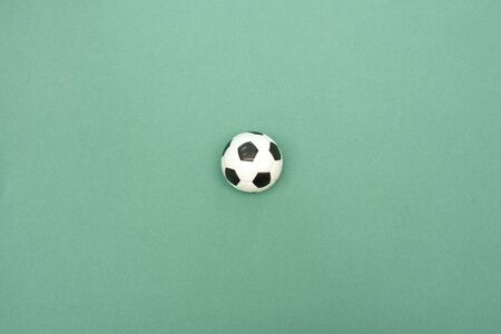 Football ball on a green field flat lay background with copy space. Game plan template.
