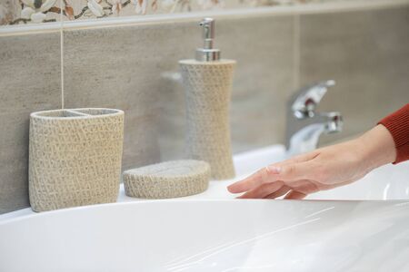 Woman is choosing new faucet and sink for bathroom in the shop.