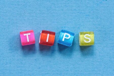 Tips inscription made of colorful small cubes on blue background.の写真素材