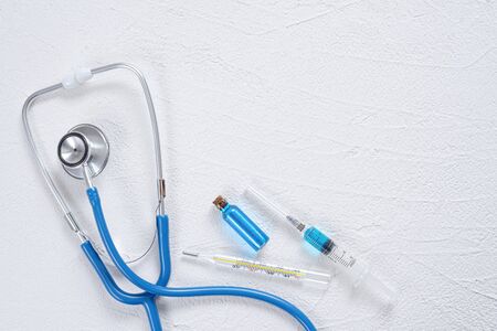 Syringe, stethoscope, thermometer and bottle with blue liquid on a white background. Medical flat...