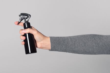 Hair spray in female hand isolated on white background.の写真素材