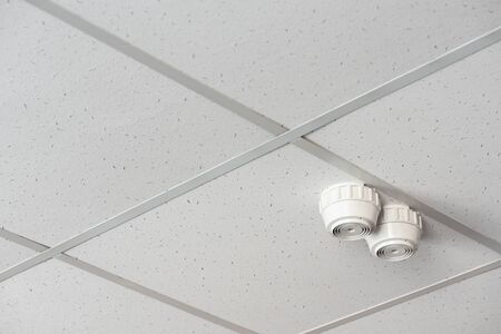 Fire alarm sensor on the ceiling of office building.