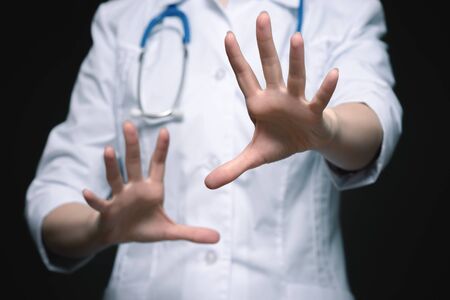 Scared doctor is holding his hands in front of him close up.の写真素材