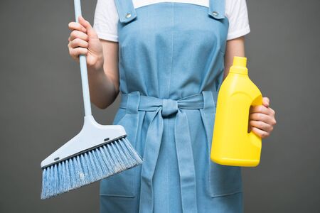 Cleaner with a dust brush and detergent bottle on gray background.の写真素材