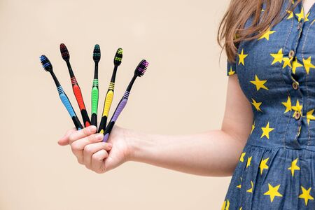 Toothbrushes in female hand close up isolated on light background.の写真素材
