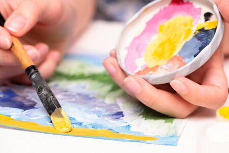 Woman is painting by a gouache close up.