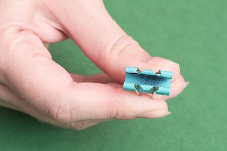 Paper clip in hand close up background.