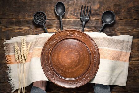Hands holding an empty plate with a copy space for food on a brown wooden kicthen table background.の写真素材