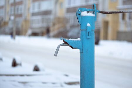 Old street water pipe stand on modern living house background.の写真素材