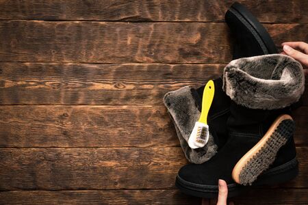 Cleaning suede boots with a shoe brush concept background with copy space.