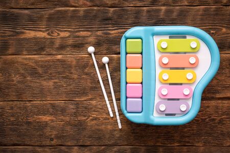 Children music instrument toy a harpsichord on wooden table flat lay background with copy space.