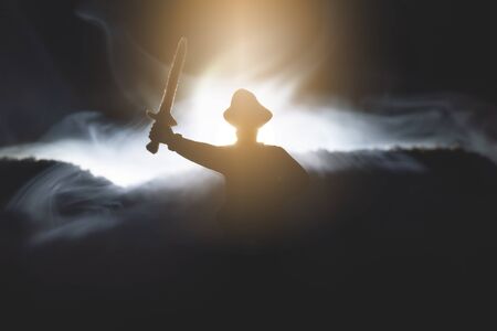 The pirate captain in the hat with raised up swords in the night fog concept.の写真素材