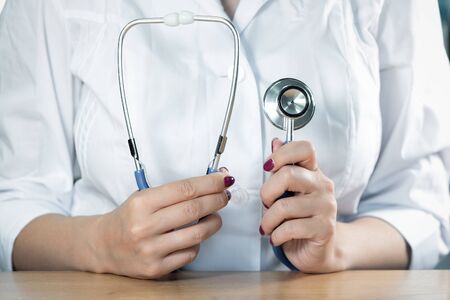 Stethoscope in a doctor hands close up.の写真素材
