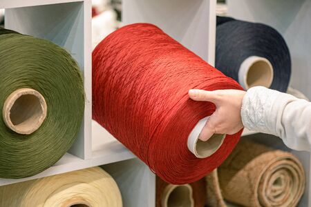Woman is choosing a rope in a sewing shop.の写真素材