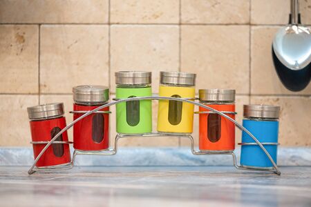 Colorful spice jars on kitchen table background.の写真素材