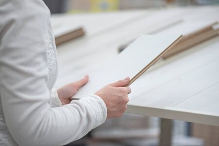 Woman is choosing a new laminate in a construction store.
