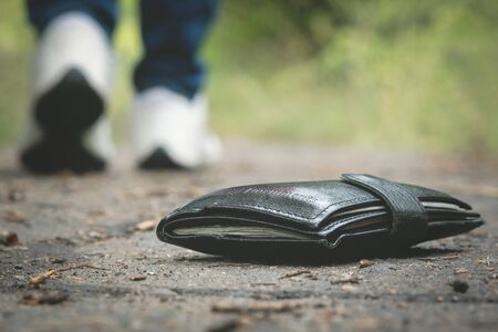 Lost wallet on road and is walking away woman.の写真素材