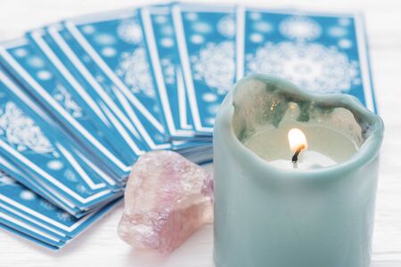 Blue tarot cards deck and burning candle close up.の写真素材