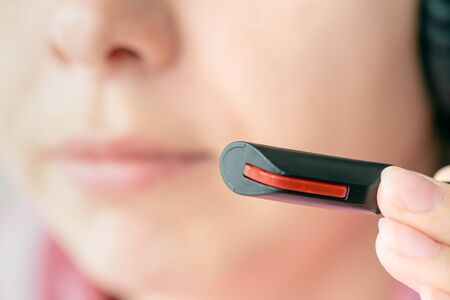 A call center worker is using a headset microphone close up.