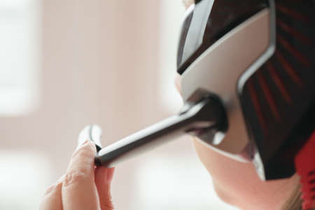 A call center worker is using a headset microphone close up.
