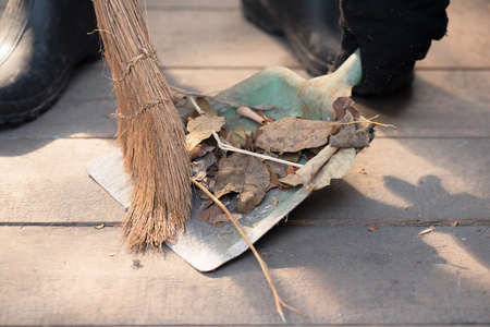 Woman is sweeping floor of countryside house close up.