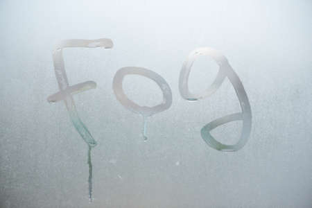 The fog the inscription on the wet window background.の写真素材