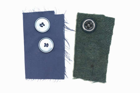 Old buttons on piece of cloth isolated on the white background.