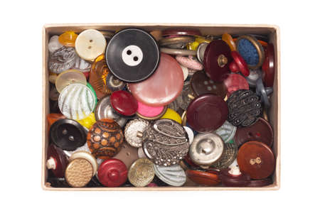 Heap of old buttons collection in a box isolated on the white background.