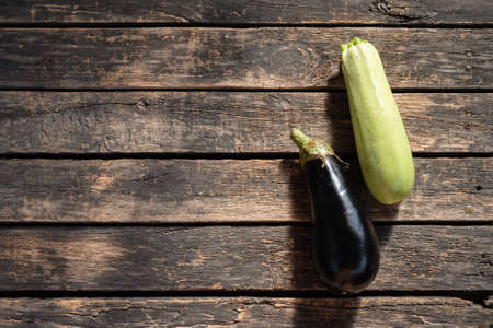 Ripe eggplant and zucchini fruits on the garden table flat lay background.の写真素材