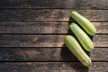 Zucchini fruit on wooden garden table background.の写真素材