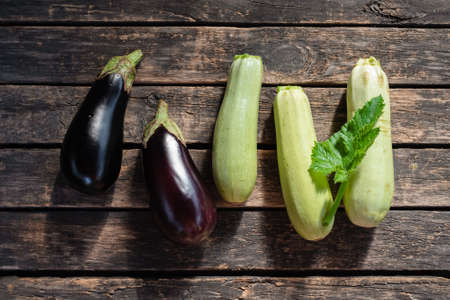 Ripe eggplant and zucchini fruits on the garden table flat lay background.の写真素材
